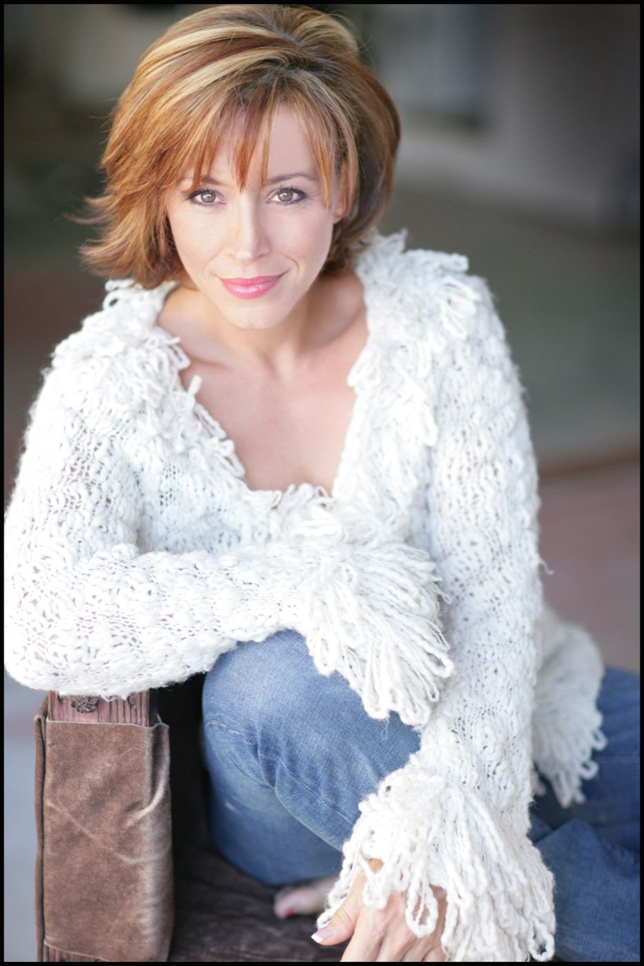 Forbes Riley seated in a white sweater, smiling