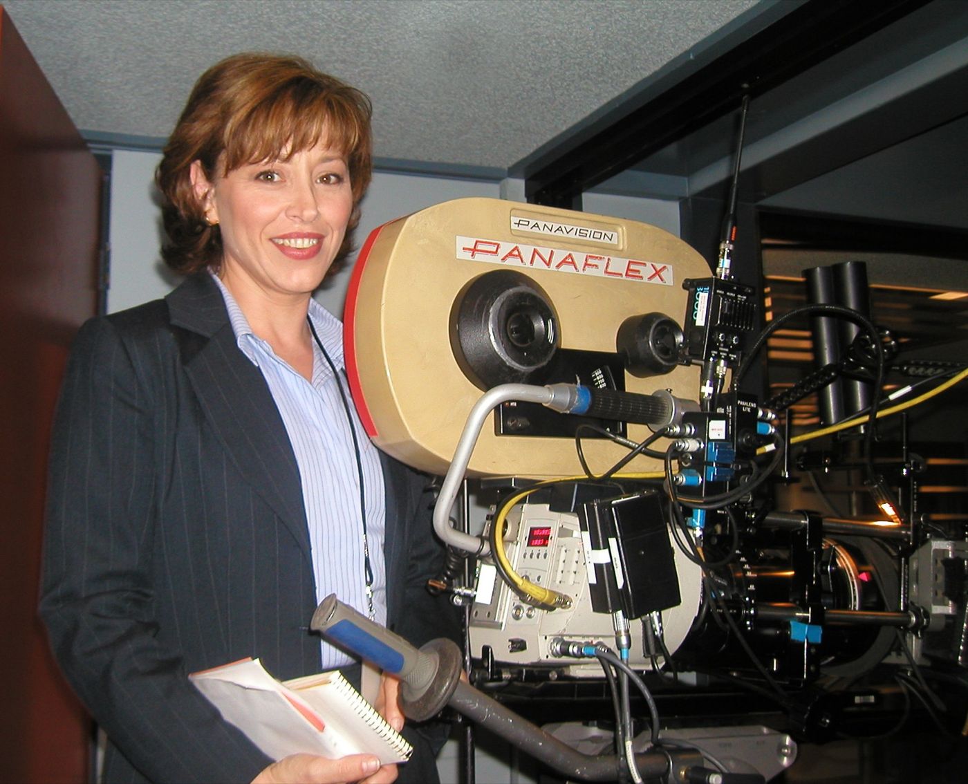 Forbes beside a Panaflex film camera on set